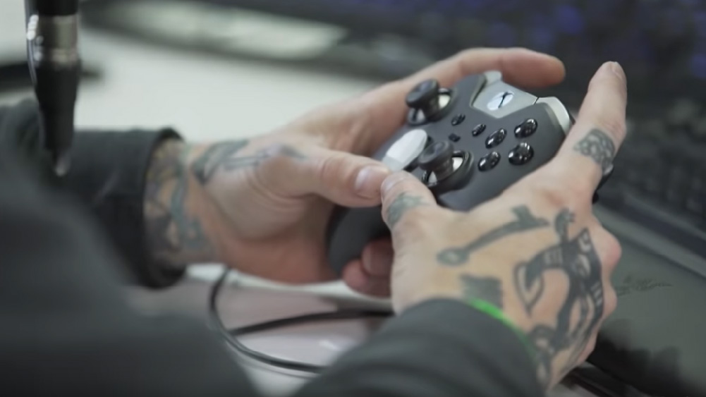 tattooed hands hold xbox one control, part of youtube channel video