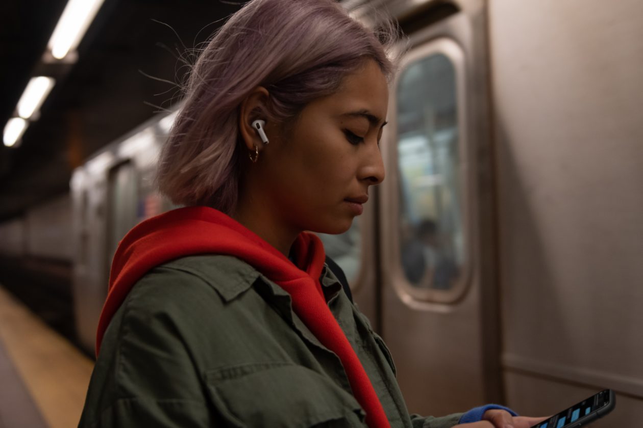 Woman using AirPods Pro on the subway