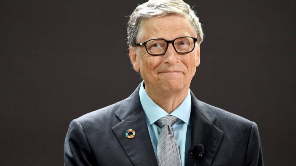 Bill Gates smiles against gray background